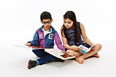 Brother and sister sitting together reading