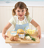 Girl holding the ingredients for potato souffles