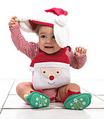 Baby girl wearing Christmas hat, bib and elf booties