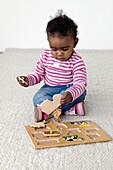 Baby girl playing with wooden puzzle