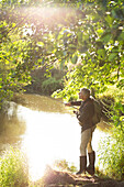 Man fly fishing on a riverbank