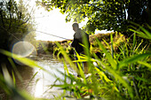 Man fly fishing at sunny river