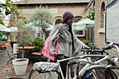 Young woman retrieving bicycle from bike rack