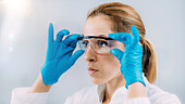 Lab technician putting protective glasses on