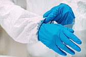 Lab technician putting on protective clothing