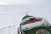 Polar icebreaker navigating through thick ice floe