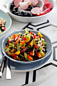 Salad of colorful peppers, celery, radish and black lentils