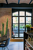 Loft living room with cactus next to window front and terrace access