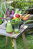 Freshly squeezed vegetable juice behind a basket of vegetables