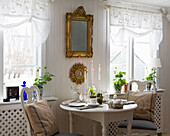 Easter table set for two, above it mirror with gold frame on the wall