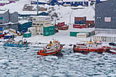 Fishing boats in the frozen harbor during a snow storm