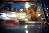 Woman driving convertible at night