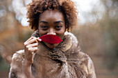 Young woman with red autumn leaf