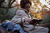 Young woman reading book in park