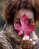 Young woman with red autumn leaf