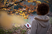 Young woman with journal in tranquil autumn park
