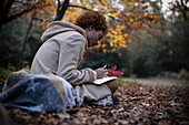 Young woman journaling in tranquil autumn park
