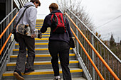 Teenage boys with skateboards climbing urban staircase