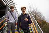 Teenage boys with skateboards and smartphone