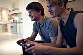 Happy teenage boys playing video game at home