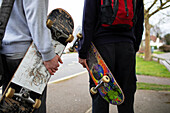 Teenage boys with skateboards on sidewalk