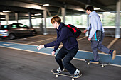 Teenage boys skateboarding in car park