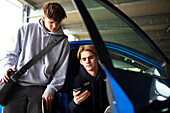 Teenage boys using smartphone in parking garage