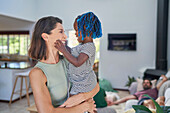 Happy mother holding daughter at home