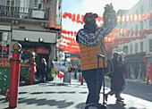Male tourist using digital camera on city street, London, UK