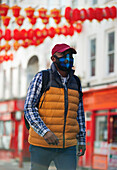 Male tourist in face mask walking in city