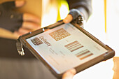 Courier holding digital tablet with delivery QR codes