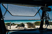 Bus window open to sunny ocean seascape