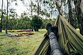 Man relaxing with feet up at campsite, Australia