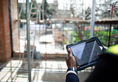 Engineer looking at blueprints on digital tablet