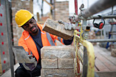 Construction worker laying bricks at construction site