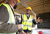 Engineer and foreman talking at construction site