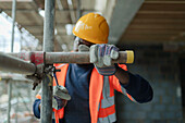 Construction worker assembling scaffolding