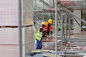 Construction workers with brick at construction site