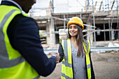 Engineer and forewoman shaking hands at construction site