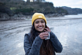 Happy young woman drinking on beach