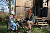 Happy young couple eating outside tiny cabin rental