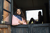 Young woman in cabin rental window