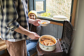 Happy young couple making stew in tiny cabin rental