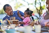 Granddaughter and grandfather at patio table