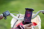Woman on bicycle checking heart rate with smartphone app