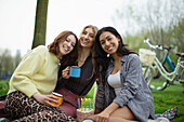 Happy young female friends celebrating birthday in park