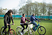Father and teen kids riding bicycles in park