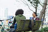Teenage friends talking on park bench