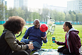 Family with soccer ball and coffee in park