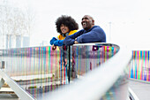 Happy father and son on modern urban footbridge